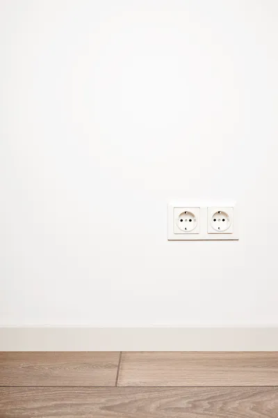 Двойная розетка для электричества на белой стене — стоковое фото