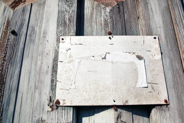Placa de metal em branco no fundo de madeira — Fotografia de Stock