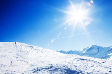 Sun over winter mountains, covered with snow clipart
