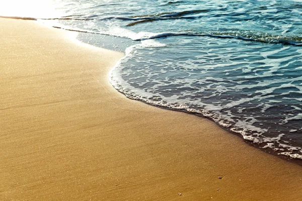 黄金のビーチの砂の上の光沢のある熱帯海の波 — ストック写真