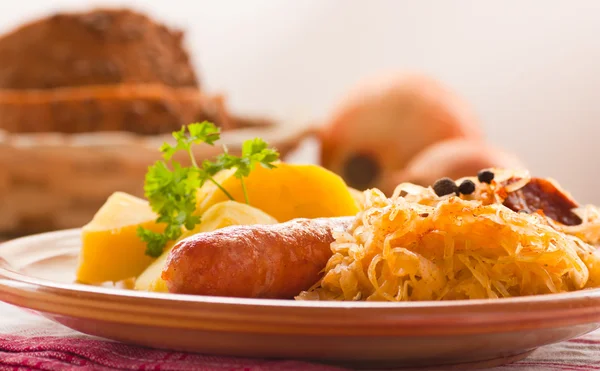 Sausage with potatoes and sauerkraut — Stock Photo, Image