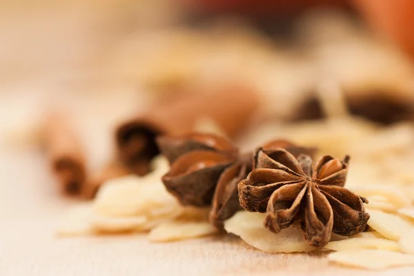 Star anise and peeled almonds with cinnamon in the back. — Stock Photo, Image