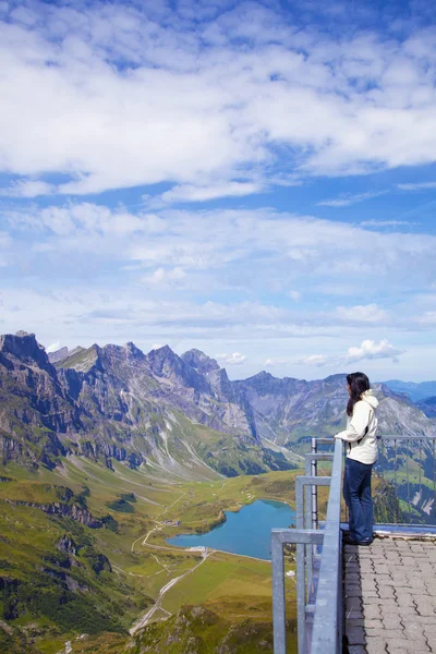 Jovem mulher em um ponto de vista de Alpes suíços — Fotografia de Stock