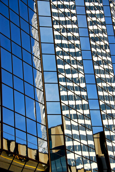 Reflections in a blue mirror glass wall of a skyscraper