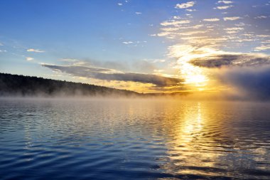 Sunrise on foggy lake clipart