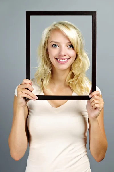 Smiling woman with picture frame — Stock Photo, Image