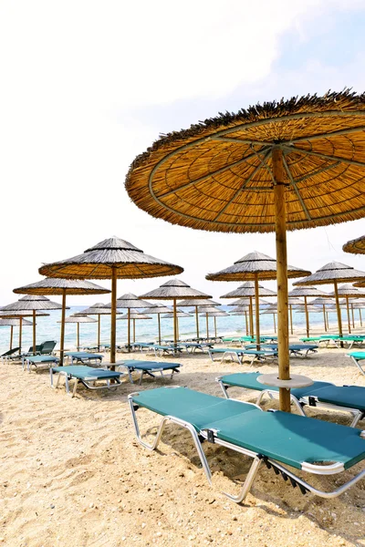 Kumlu sahil üzerinde plaj şemsiyeleri — Stok fotoğraf