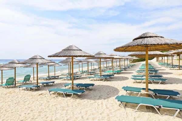 Strand parasols op zanderige kust — Stockfoto