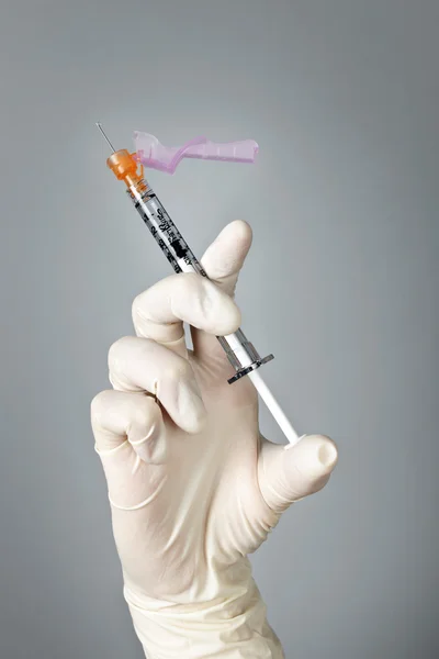 Syringe held by gloved hand — Stock Photo, Image