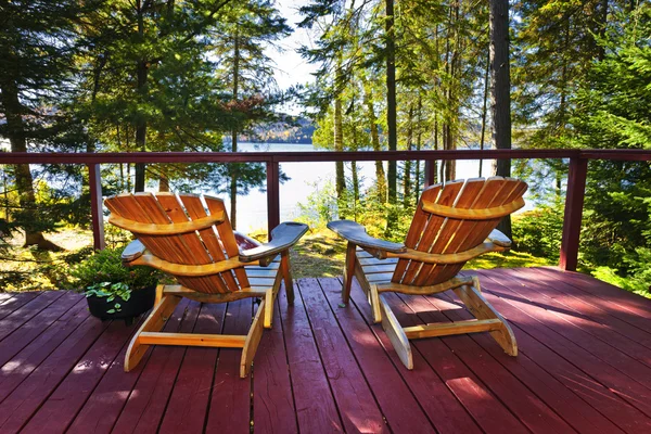 Bosque cabaña cubierta y sillas — Foto de Stock