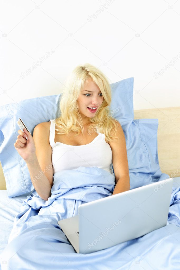 Woman shopping in bed with computer