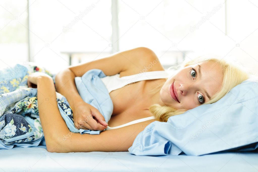 Smiling woman laying in bed