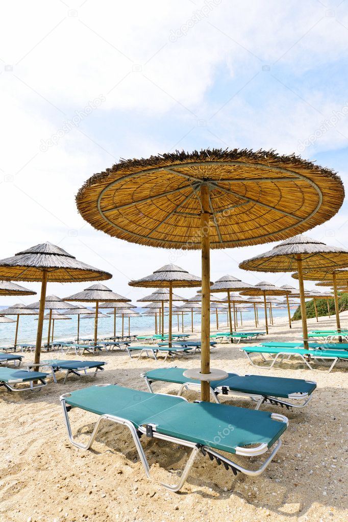 Beach umbrellas and chairs on sandy seashore
