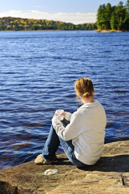 Woman relaxing at beautiful lake clipart