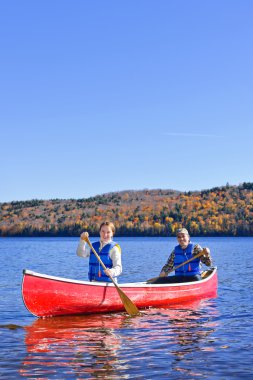 Canoe trip on scenic lake in fall clipart