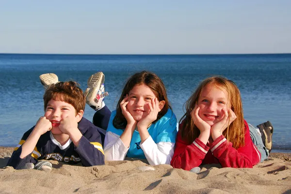 Tres niños en una playa — Foto de Stock