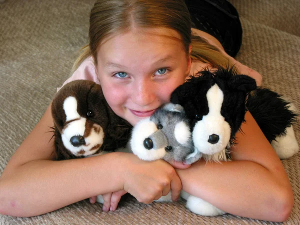 Menina abraçando seus brinquedos de pelúcia — Fotografia de Stock