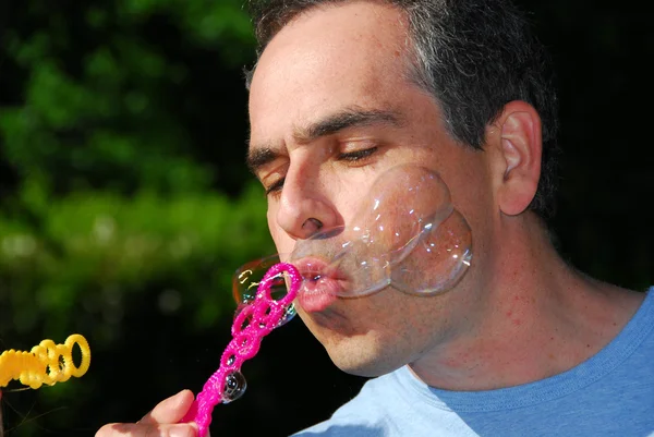Homme soufflant des bulles — Photo