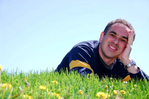 Улыбающийся человек на траве — стоковое фото