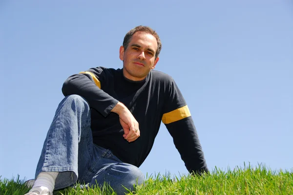 Человек сидит на траве — стоковое фото
