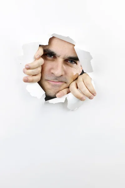 Cara mirando a través del agujero en papel — Foto de Stock