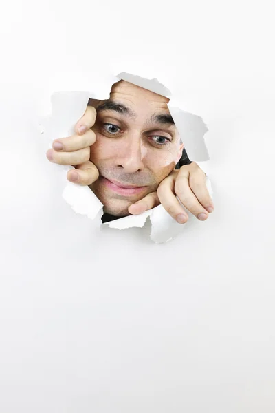 Cara mirando a través del agujero en papel —  Fotos de Stock