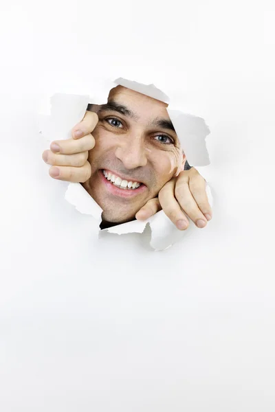 Cara feliz olhando através do buraco no papel — Fotografia de Stock