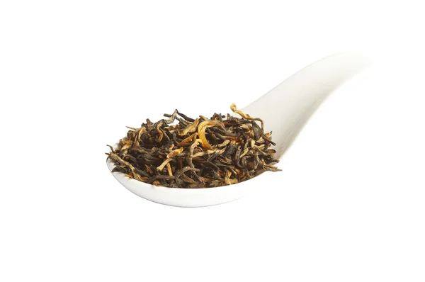 Black loose Yunnan tea in spoon, isolated — Stock Photo, Image