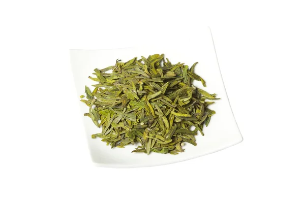 Тарелка с зелеными сухими листьями чая, изолированные — стоковое фото