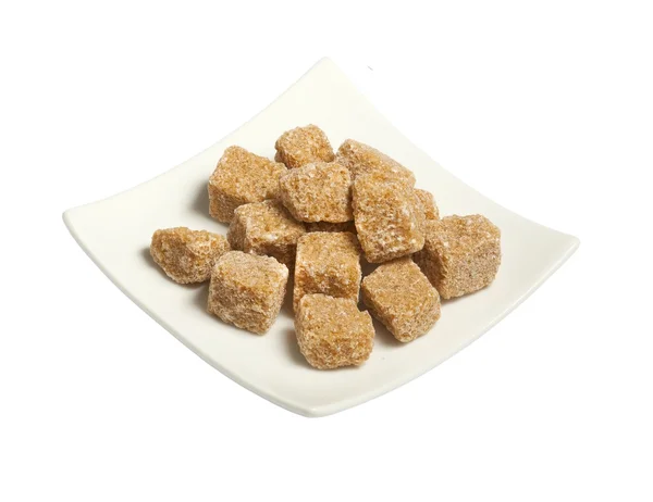 Cubes of brown cane sugar in plate, isolated on white — Stock Photo, Image