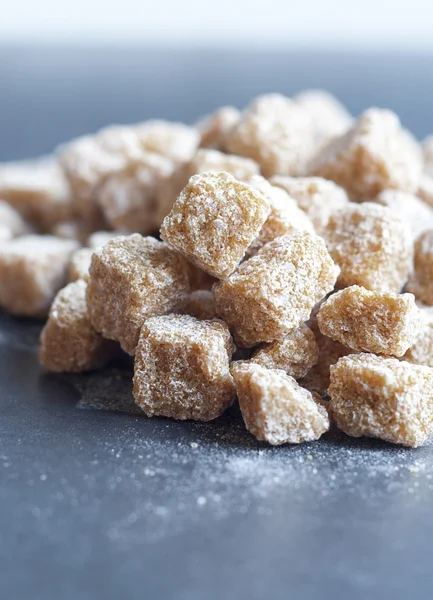 Cubes of brown whole cane sugar, shallow focus — Stock Photo, Image