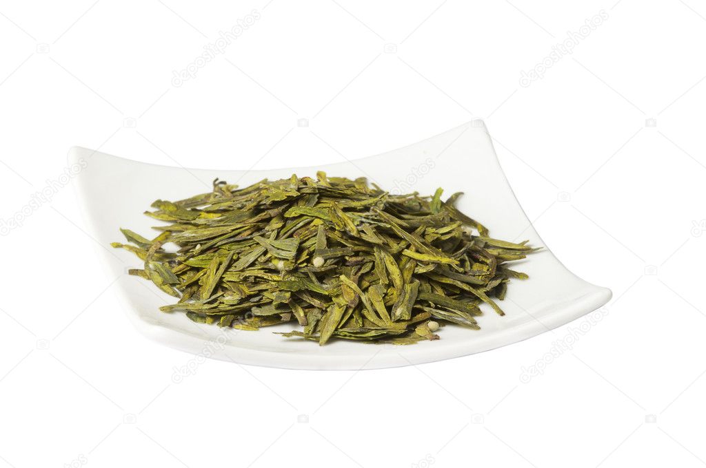 Plate with loose green dry tea, isolated