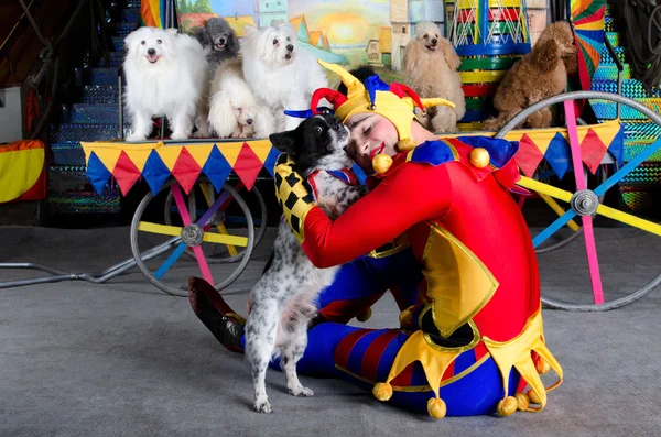 Улыбающийся клоун обнимает свою собаку — стоковое фото