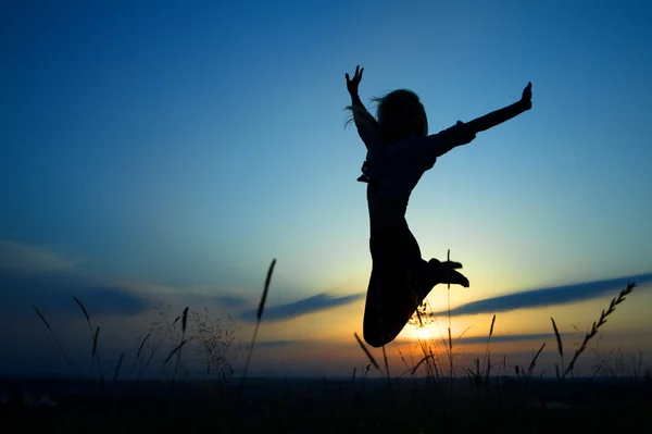 Silueta dívka, která skočila přes slunce — Stock fotografie