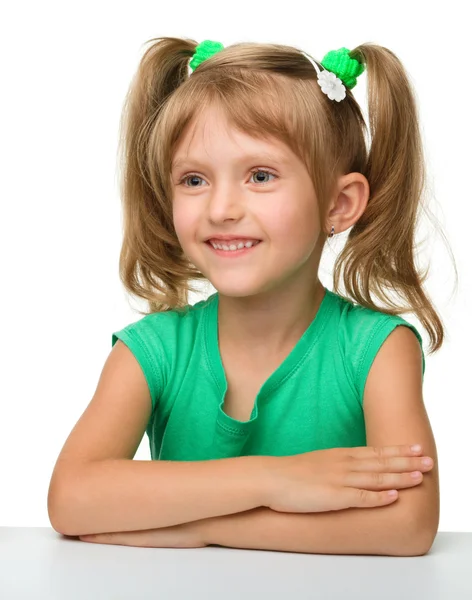 Mutlu küçük kız masada oturuyor — Stok fotoğraf