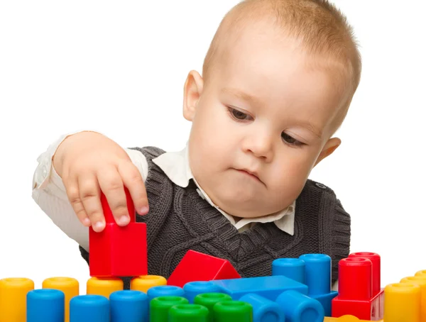 Niño juega con ladrillos de construcción — Foto de Stock