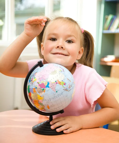 Kleines Mädchen spielt mit Globus — Stockfoto