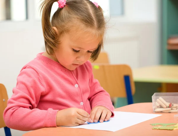 Маленька дівчинка грається з олівцями — стокове фото