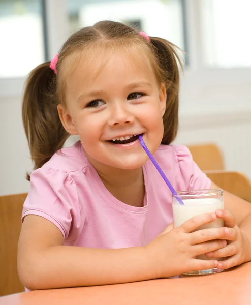 Маленька дівчинка п'є молоко — стокове фото
