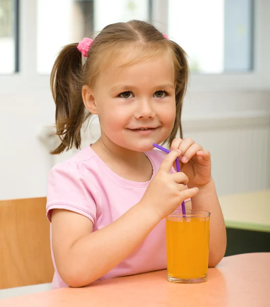 小さな女の子はオレンジ ジュースを飲んでいます。 — ストック写真