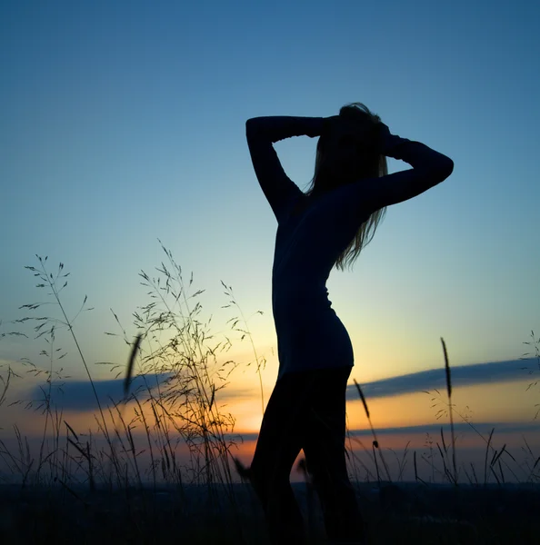 Silhueta de uma menina sobre o pôr do sol — Fotografia de Stock