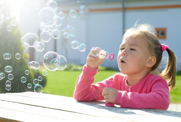 Klein meisje is zeepbellen blazen — Stockfoto