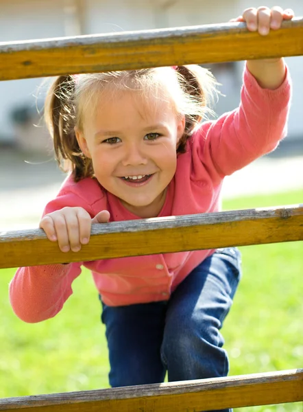 Roztomilá holčička je lezení nahoru na žebřík — Stock fotografie