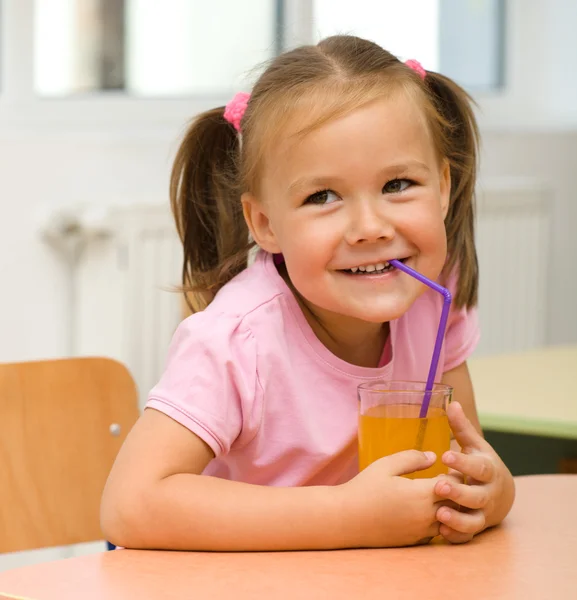 Klein meisje is drinken sinaasappelsap — Stockfoto