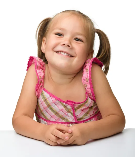 Ευτυχισμένη κοριτσάκι κάθεται στο τραπέζι — Φωτογραφία Αρχείου