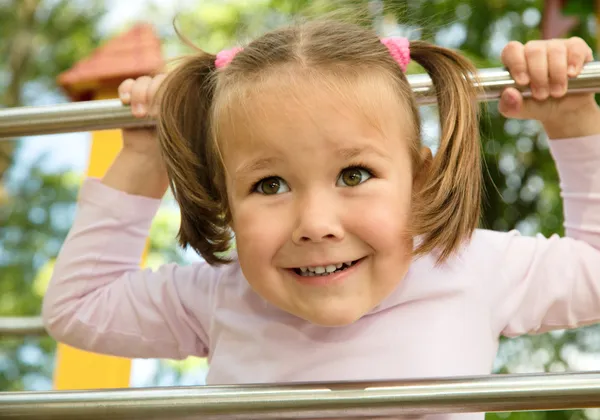 Dziewczynka bawi się w plac zabaw dla dzieci — Zdjęcie stockowe