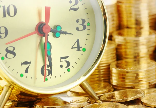 El tiempo es dinero - marcación del reloj y monedas de oro —  Fotos de Stock
