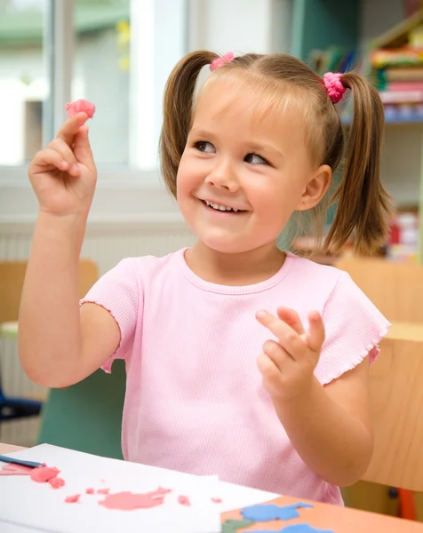 Little girl is playing with plasticine Stock Image