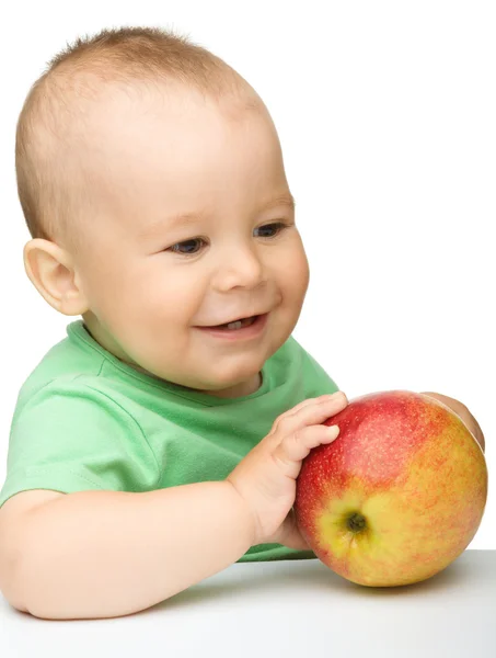 Pequeño niño está mordiendo manzana roja — Foto de Stock