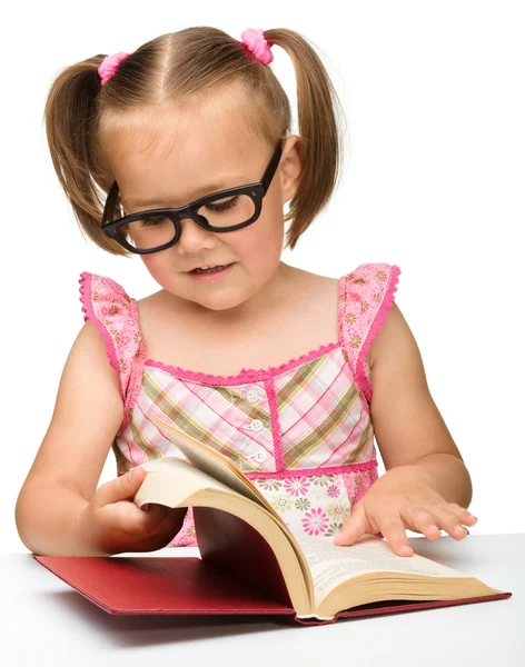 Little girl is flipping over pages of a book — Stock Photo, Image